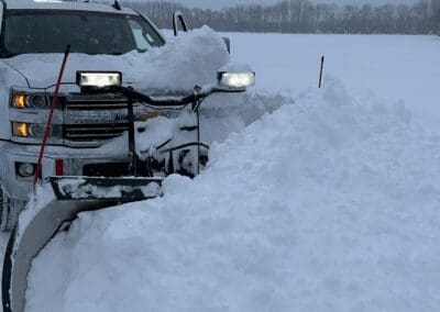 A white truck plowing snow
